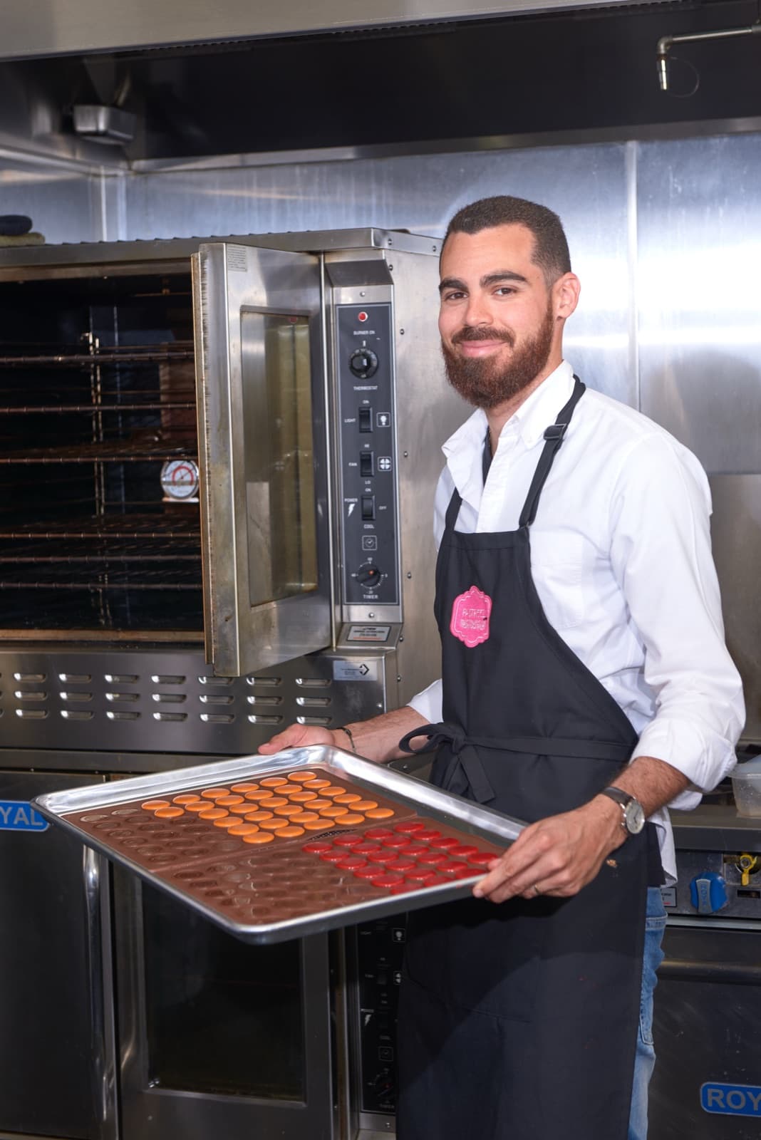 Anthony Rosemond holding a tray of fresh macarons